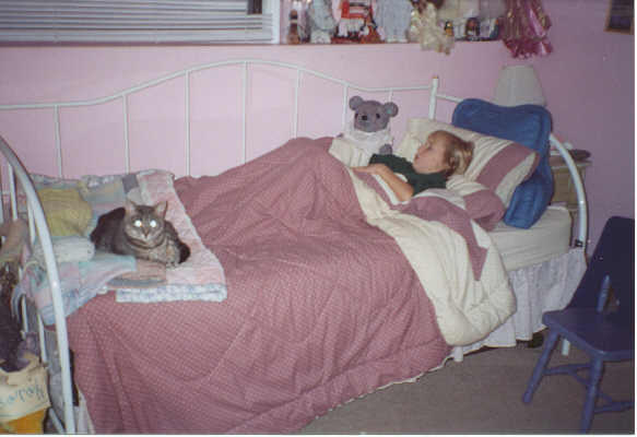 Sarah sleeping with Blue Bear and Princess, her cat.